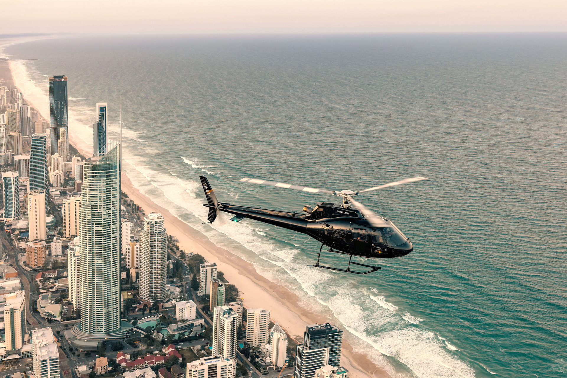 Gold Coast Helitours helicopter over the coast
